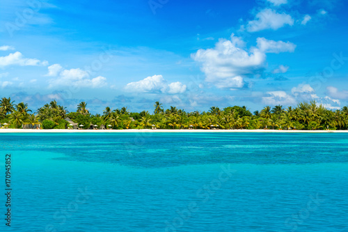 Fototapeta Naklejka Na Ścianę i Meble -  Beautiful sandy beach with sunbeds and umbrellas in Indian ocean, Maldives island
