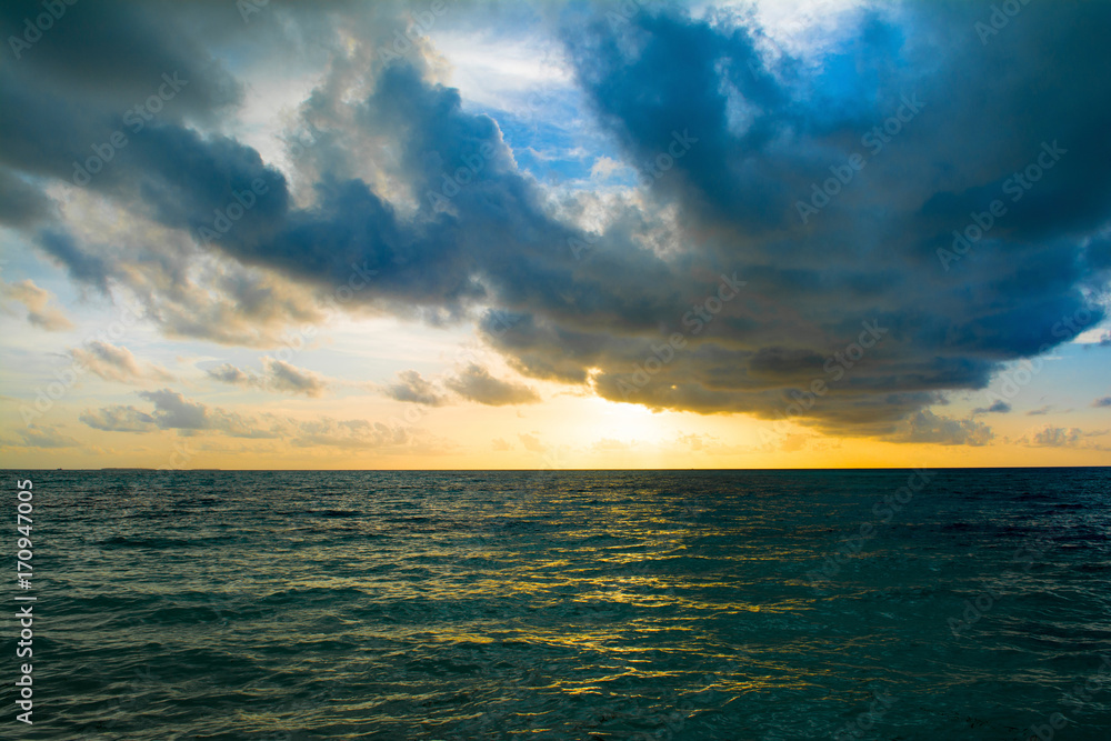 Naklejka premium Landscape of beautiful sunset in Maldives island sandy beach with colorful sky over wavy sea