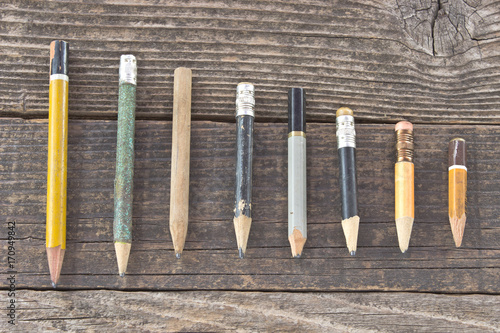 Old wooden pencils on wooden background