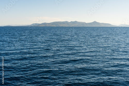 Deep blue sea with mountains on a horizon
