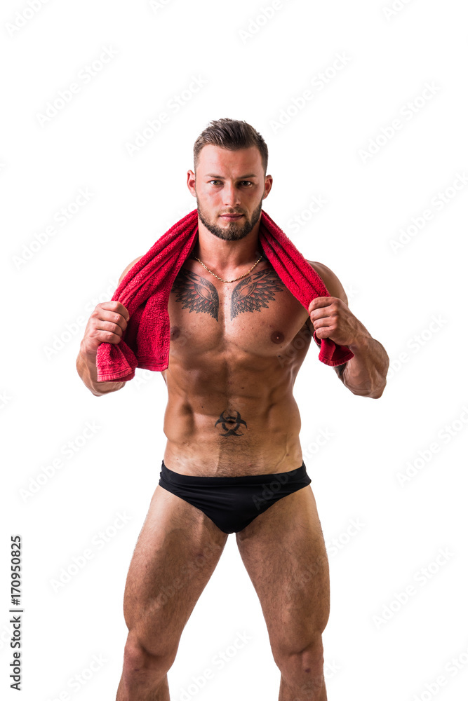 Handsome shirtless muscular man in briefs, standing, isolated on white background