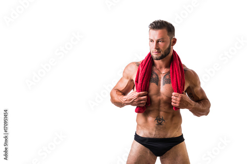 Handsome shirtless muscular man in briefs, standing, isolated on white background
