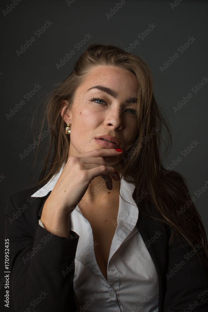 High fashion portrait of young elegant sexy slim brunette woman posing in studio wearing fashionable black jacket suit and white shirt. High fashion portrait of young elegant sexy slim brunette woman posing in studio wearing fashionable black jacket suit and white shirt.