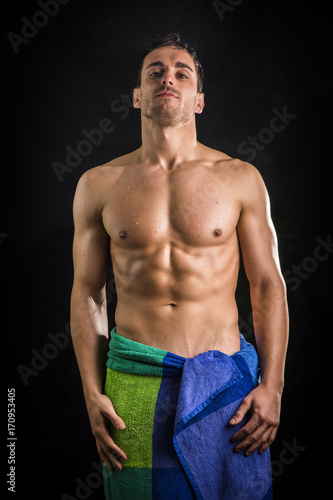 Portrait of naked handsome young man with languishing look with a towel around his waist