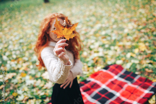 redhead girl on red plaid in autumn park