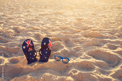 Thongs and sunglasses on beach sand