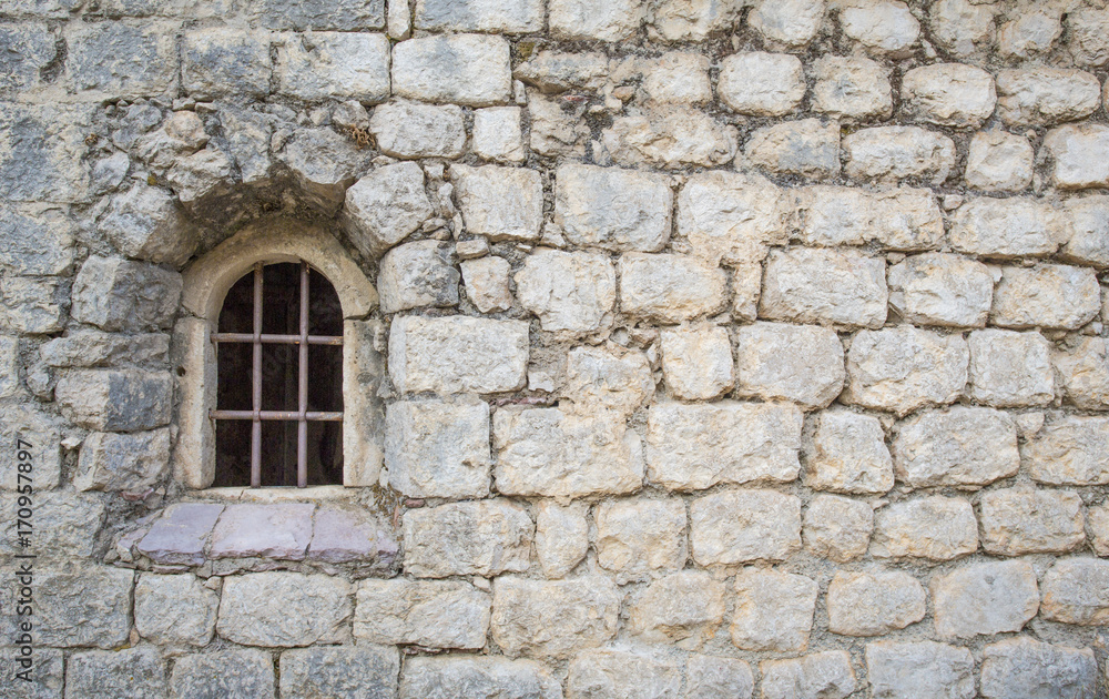 window with a bar in the old church. Stone wall.