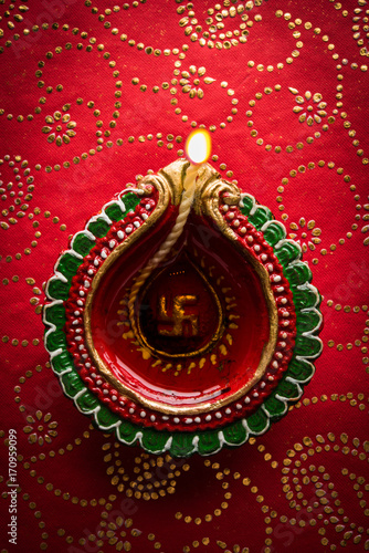 Photography stock photo of beautiful diwali diya, isolated over decorative background, moody