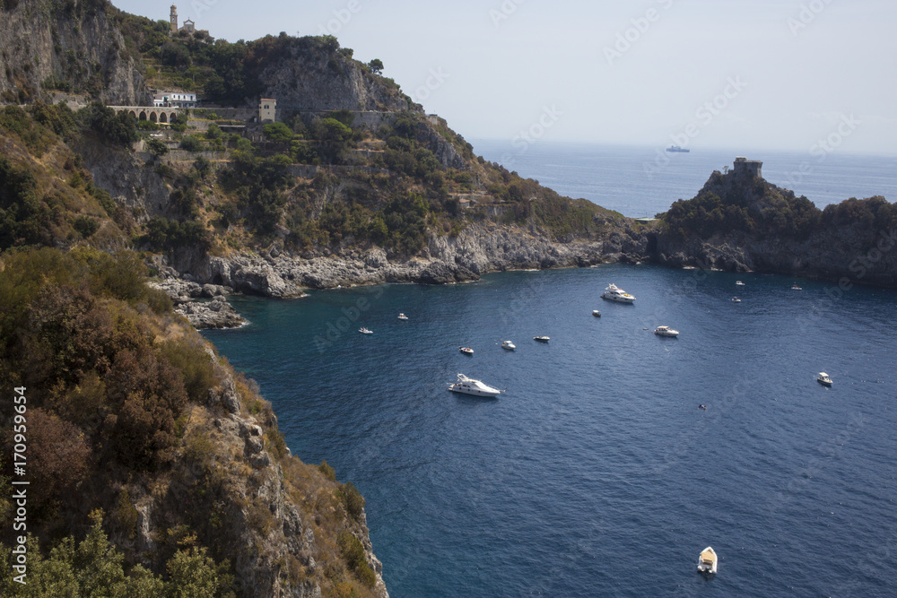 Piccolo golfo naturale lugno la costiera amalfitana tra Positano e Amalfi. Il mare è calmo e le barche dei turisti sono ancorate. L'acqua è pulita e blu e il cielo è splendente.