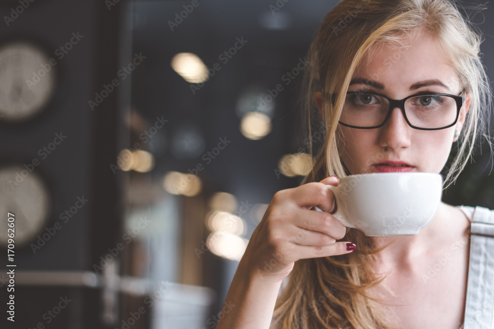 Coffee is the best way to start my day successful. Closeup shot of attractive young woman holding a cup of coffee and looking at camera. Coffee is the best way to start my day successful. Closeup shot of attractive young woman holding a cup of coffee and looking at camera.