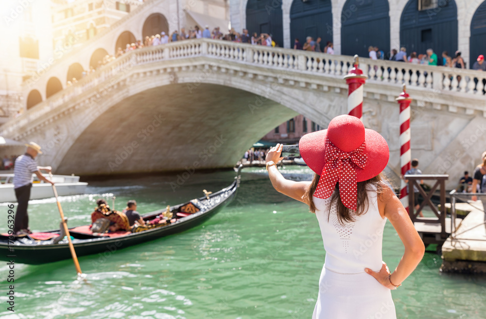 Fototapeta premium Elegante, weibliche Touristin fotografiert die Rialto Brücke in Venedig, Italien