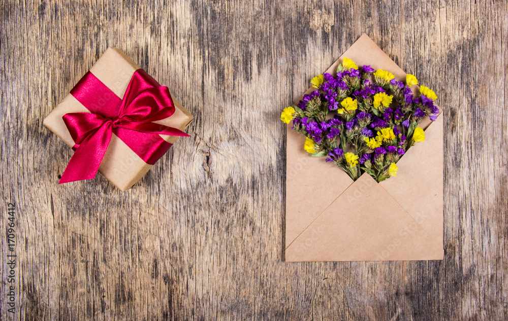 Romantic message. A living letter. Wild flowers in the envelope and a box with a gift. Copy space