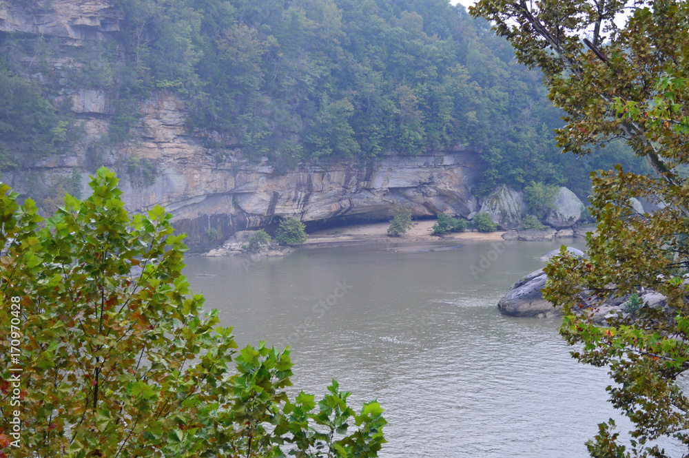 photo of the river bordered by rocky bluffs on a rainy day