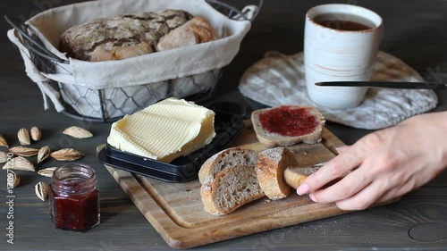 a woman smeared black bread with oil using a knife. He picks up the oil from the oilcan and smears it on the bread. photo