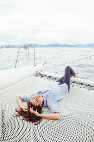 Woman lie on ship deck while enjoying a cruise on a yacht