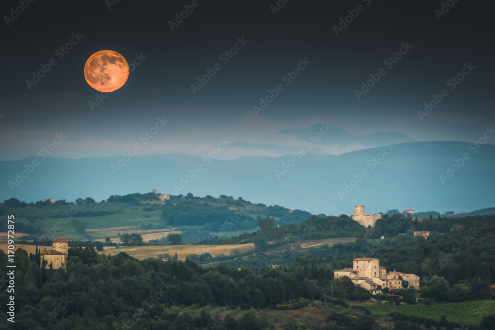 Full moon rising over Umbrian countryside in Italy