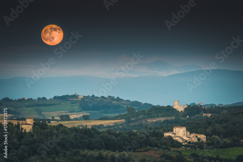 Full moon rising over Umbrian countryside in Italy