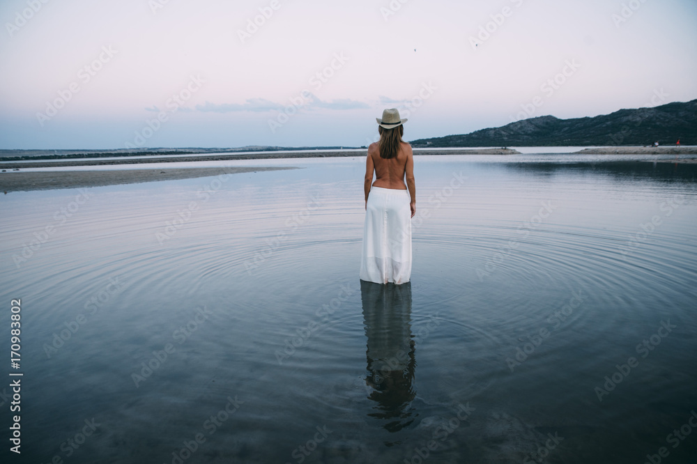 Woman with hat in the lake