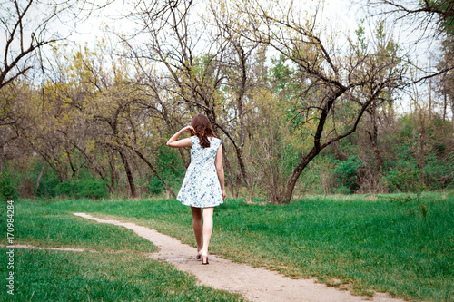 Woman or girl in a dress standing in a park
