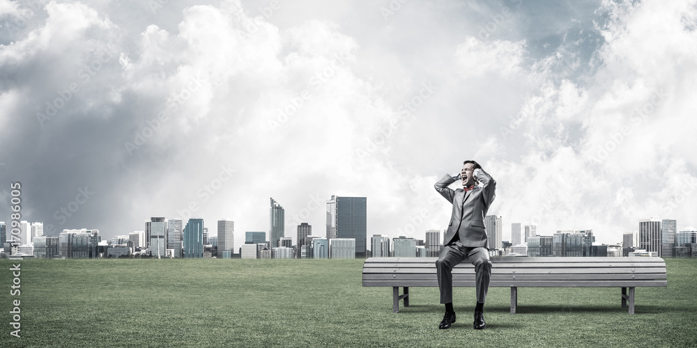 Young man in suit in park dont want to hear anything