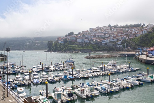 Foto boats in a port in Lastres with the village behind, Asturias, Spain