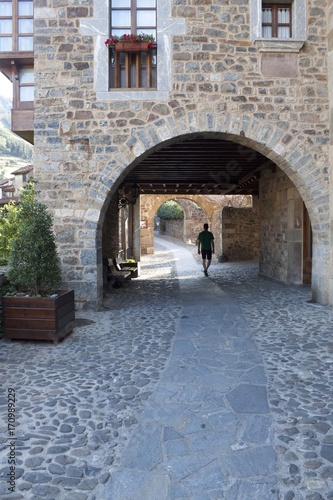 guy walking through the street in a stoned village, Potes, Spain © MonikM