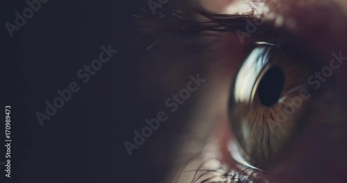 Macro Close-up Eye Blinking. SLOW MOTION 4K DCi. Young Woman is opening and closing her hazel eye. Eyesight health. Cinematic close up shot on dark background.