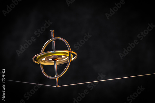 Toy gyroscope balancing on a line photo
