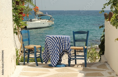 Traditional Greek blue table and chairs by the Aegean sea  Aegina island