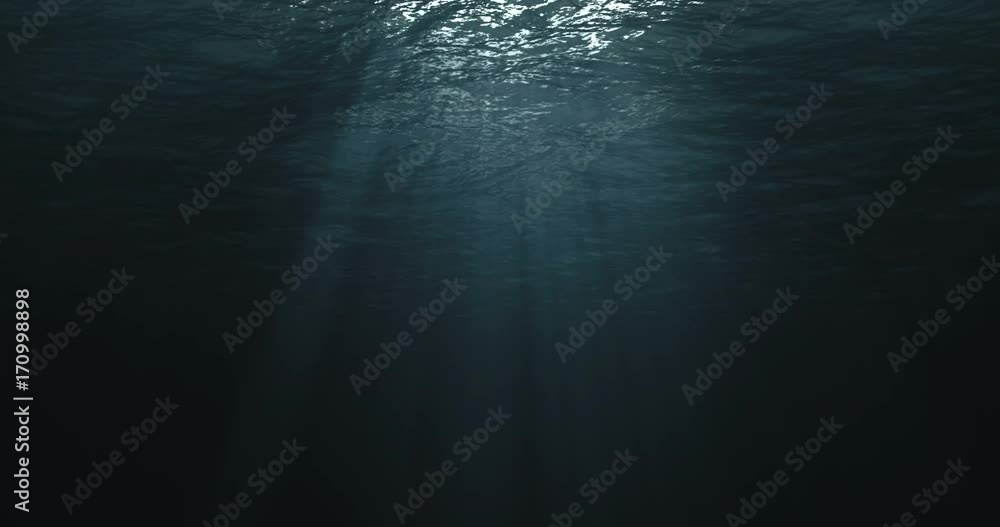 perfectly seamless loop of deep blue caribbean ocean waves from underwater background, light rays shining through