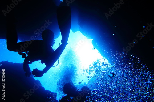 海底の洞窟内を泳ぐダイバー