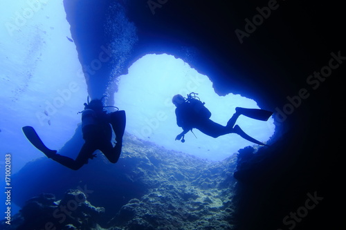 海底の洞窟内で泳ぐダイバー