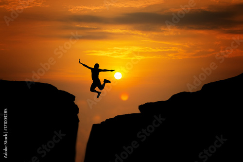 silhouette of man travel jump up for achievements successful and celebrating success with sunrise