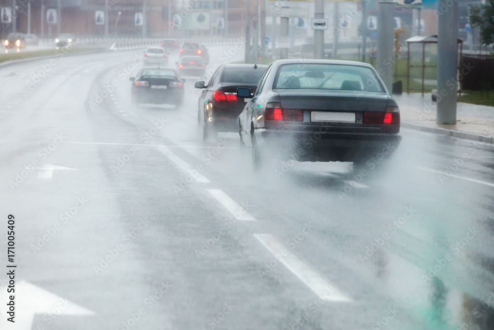 traffic during bad weather. moving cars spraying rain puddles. 