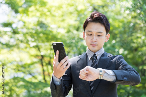 asian businessman using smart phone in park