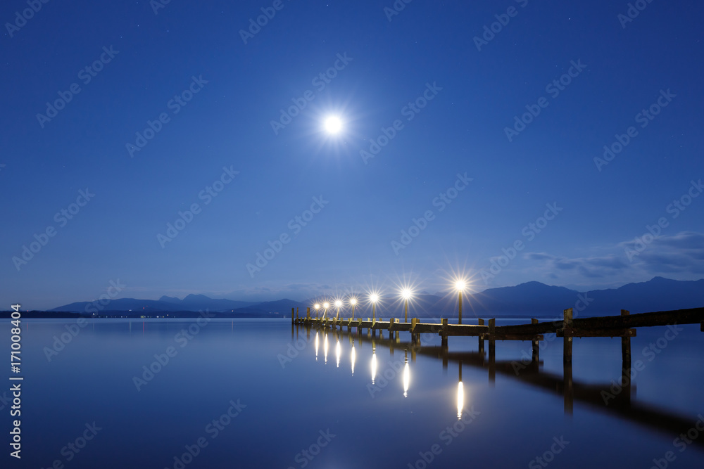 Fototapeta premium Jetty at Full Moon at Lake Chiemsee with Alps in Background, Rosenheim, Bavaria, Germany, Long Time exposure, soft