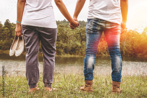 Lover men and women Asian relax in the holiday. Hold hands walking foot on the meadow