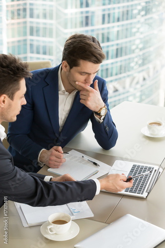 Εκτύπωση καμβά Business partners using laptop while working together on important corporate project in office