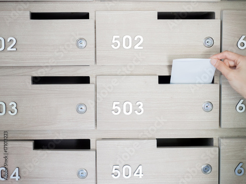 Close-up of person's hand . hand removing a letter from mailbox in the entrance hall of an apartment building
