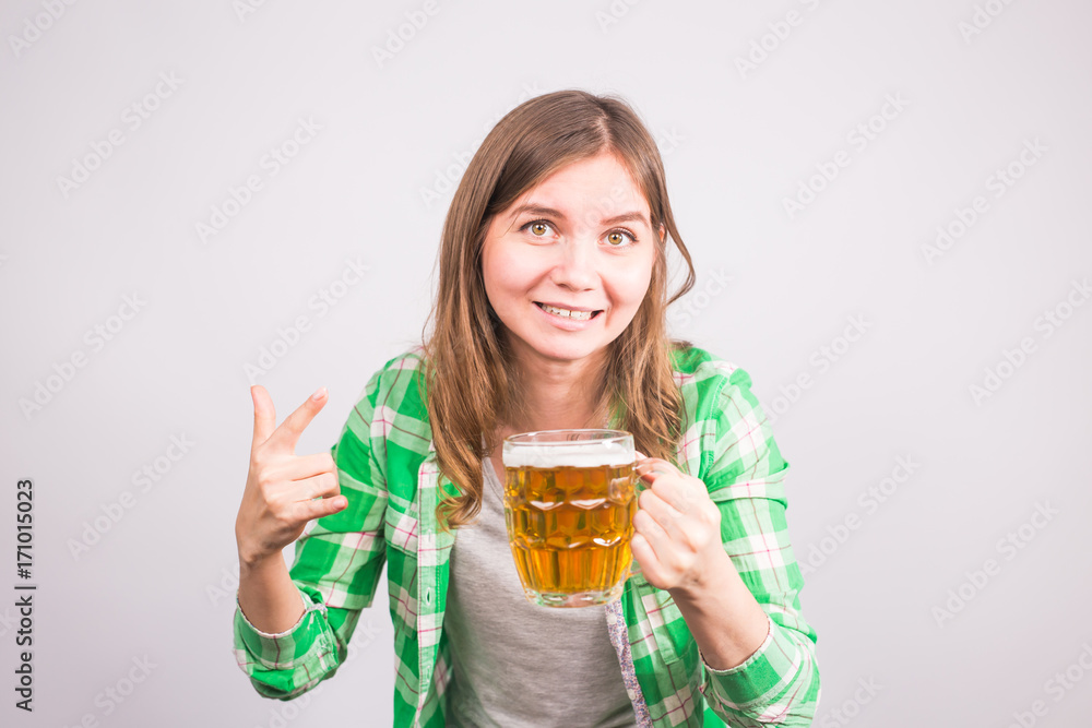 Cheerful young woman holding a beer mug full of beer and smiling on white background Cheerful young woman holding a beer mug full of beer and smiling on white background