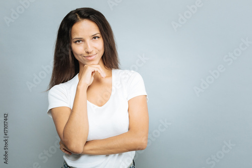 Thoughtful female person touching her chin