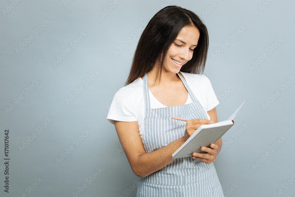 Attentive brunette writing down new recipe Attentive brunette writing down new recipe