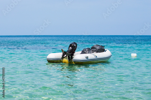 Inflatable dinghy boat with outboard motor moored in tropical sea © rostovdriver