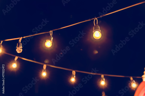 Selective focus on Light bulbs and  bokeh background with effect filter, Abstract background, vintage tone at night light festival.