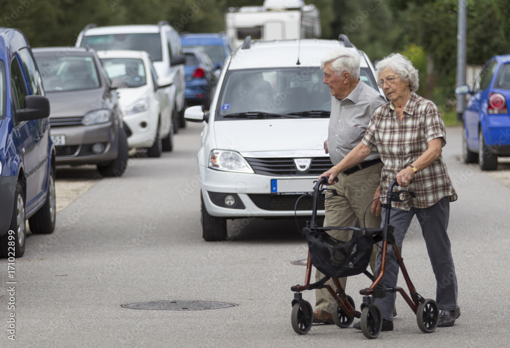 Seniorenpaar am Rollator überquert die Straße Seniorenpaar am Rollator überquert die Straße