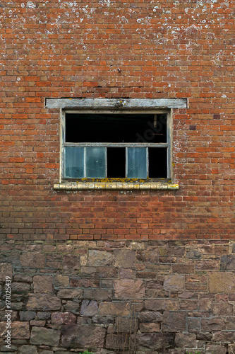 The old brick wall with broken glass window as background © Maksims