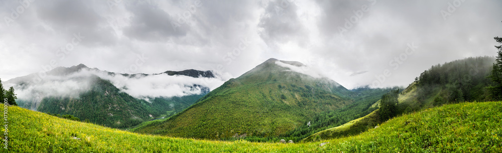 Mountain range covered with haze and clouds in evening, national park in Altai republic, Siberia, Russia Mountain range covered with haze and clouds in evening, national park in Altai republic, Siberia, Russia