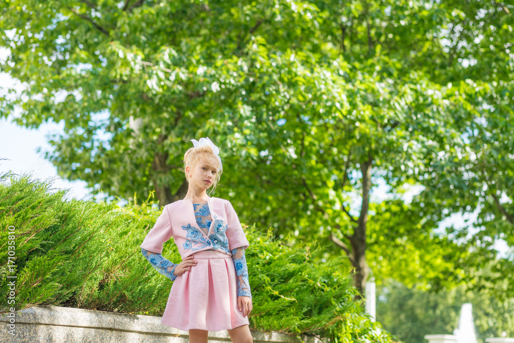 Portrait of a blonde in pink attire in a park outdoors. Portrait of a blonde in pink attire in a park outdoors.