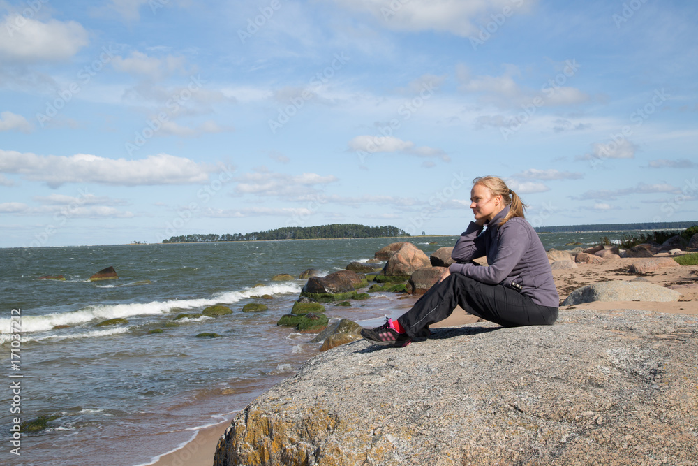 Pretty and natural woman enjoys the nature at the wild beach in the Lahemaa National Park, Käsmu, on the horizon the island Kuradisaar, stormy, summer Pretty and natural woman enjoys the nature at the wild beach in the Lahemaa National Park, Käsmu, on the horizon the island Kuradisaar, stormy, summer