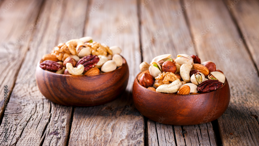 Nuts Mixed in a wooden plate.Assortment, Walnuts,Pecan,Almonds,Hazelnuts,Cashews,Pistachios.Concept of Healthy Eating.Vegetarian.selective focus. Nuts Mixed in a wooden plate.Assortment, Walnuts,Pecan,Almonds,Hazelnuts,Cashews,Pistachios.Concept of Healthy Eating.Vegetarian.selective focus.